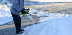 Snow removal loader clearing a residential driveway in winter